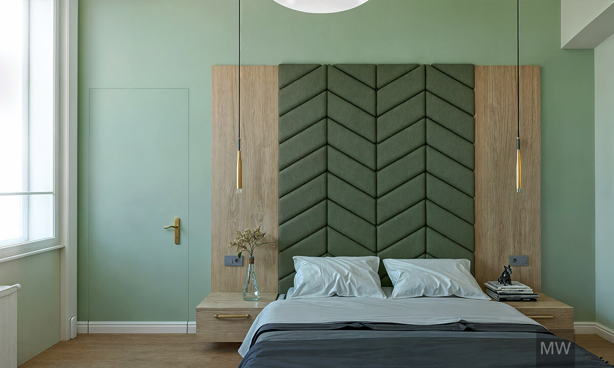 Modern Bedroom Design with Geometric Wall and Elegant Pendant Lights | Most Wanted Design Cluj Contemporary bedroom with muted green walls, dark blue bedspread, geometric padded wall design, pendant lights with gold fixtures, and wooden nightstand with dried branches.