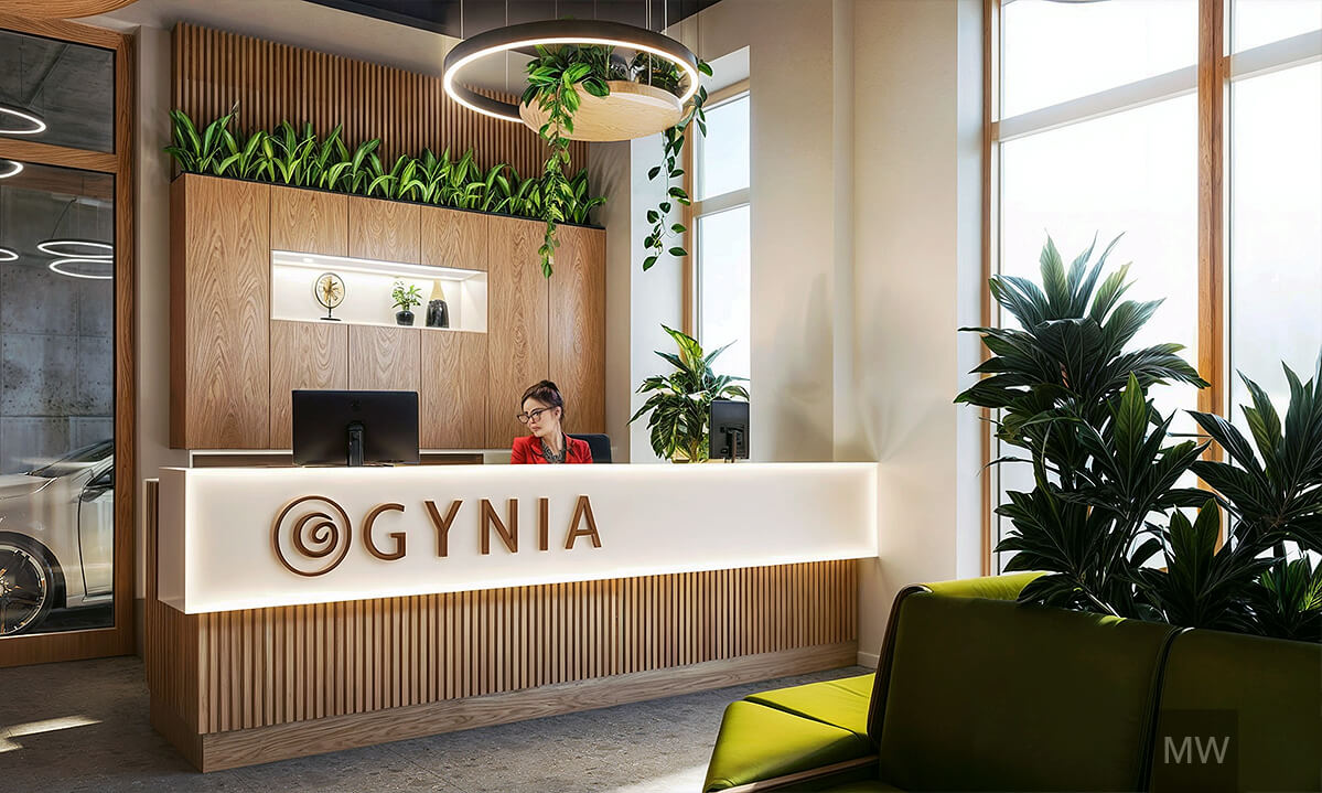 Recepție modernă Gynia cu accente naturale și design contemporan Recepție modernă cu logo 'Gynia' pe suport alb de corian și accente de plante verzi