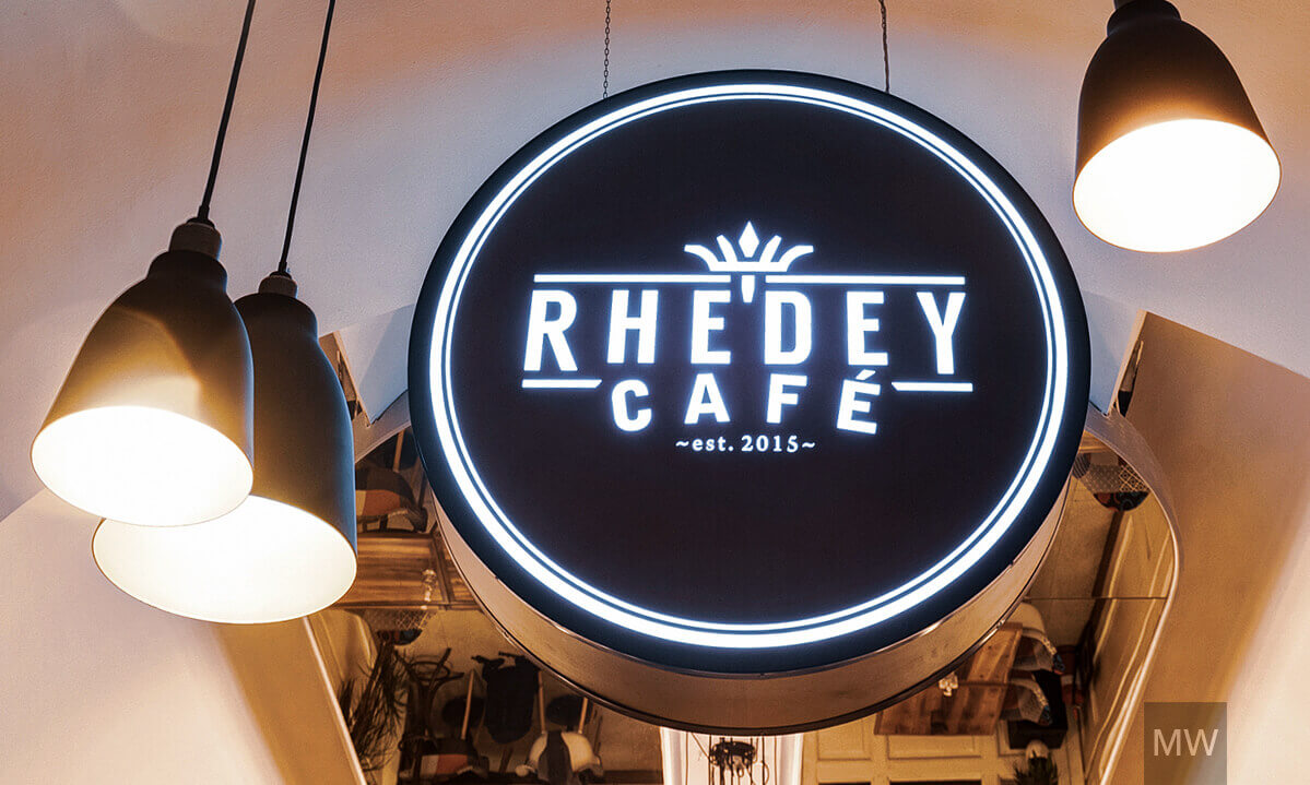 rhedey-cafe-mostwanted-design-interior-commercial-004 firmă luminoasă cu logo-ul Rhedey în mijlocul restaurantului