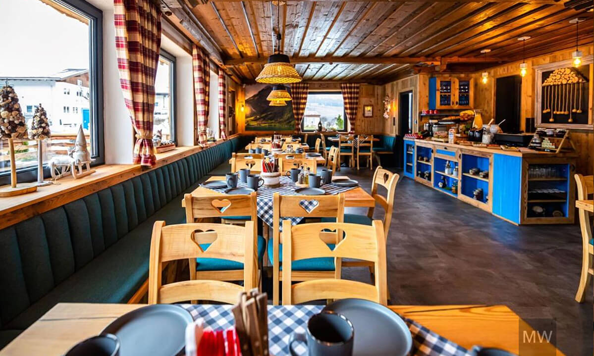 Restaurant rustic cu decor cald și feronerie din lemn. Restaurant cozy cu pereți din lemn și vedere la peisajul snowy.