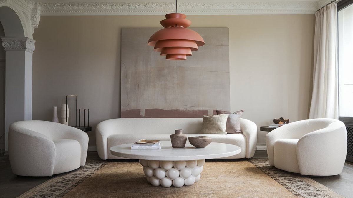 Living elegant cu masă rotundă și lumină chihlimbar. O cameră de zi elegantă cu o masă rotundă albă în centrul camerei, având o bază unică, asemănătoare unui grup de sfere albe. Pe masă se află câteva obiecte decorative, inclusiv o carte și un vazon. Deasupra mesei atârnă un iluminat cu un design etajat, de culoare chihlimbar. La stânga, un sofă albă cu perne decorative. În spatele acesteia, o pictură abstractă mare. Camerele prezintă muluri pe tavan și o fereastră mare cu draperii albe. Un covor cu model adaugă textură camerei.