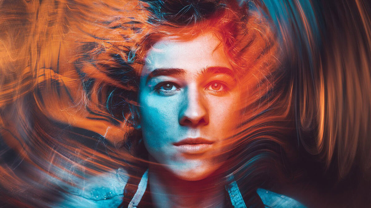 Intense Abstract Portrait with Swirling Colors A close-up of a face enveloped in swirling orange, blue, and red hues, creating a sense of motion and mystery.