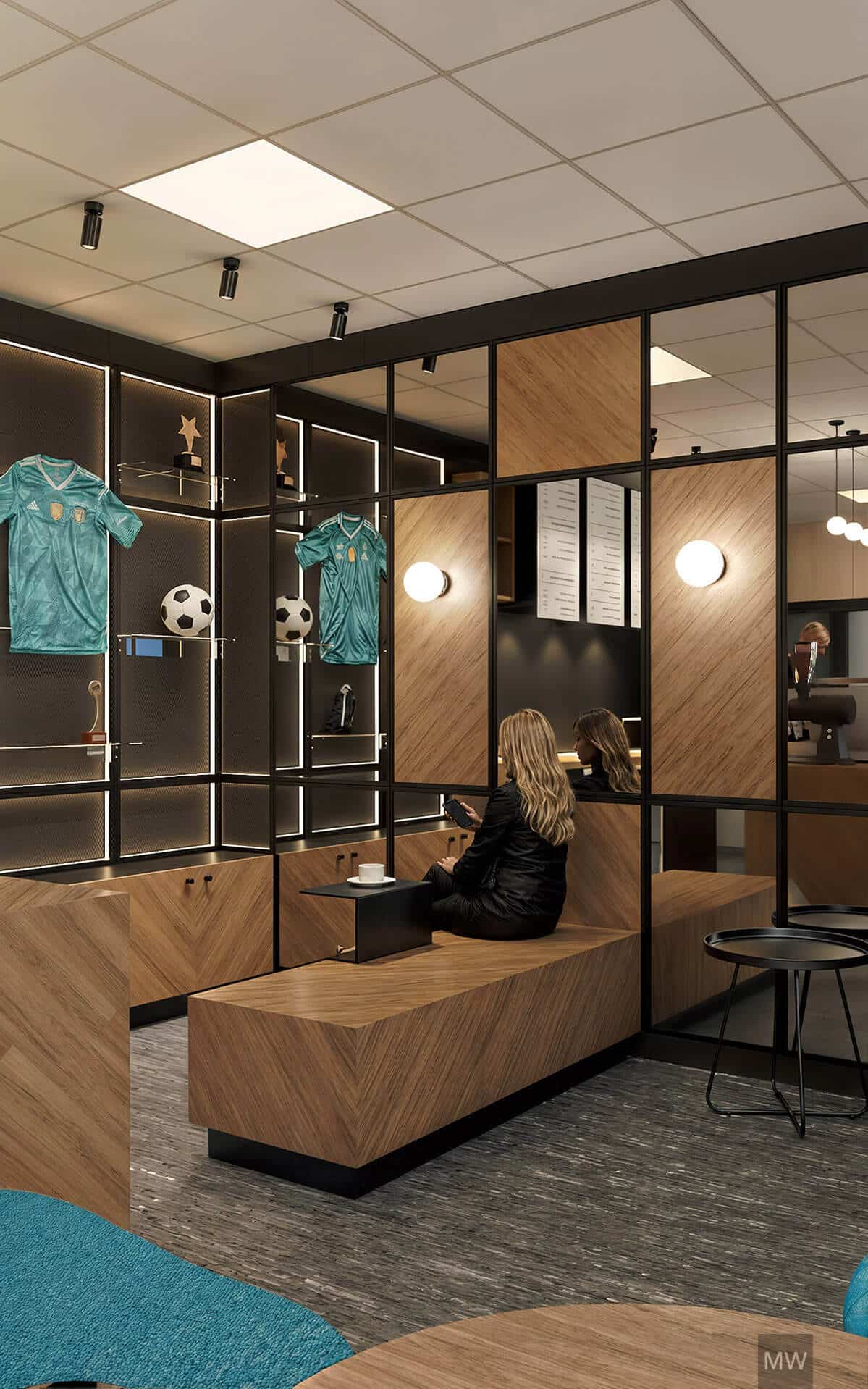 cafenea-moderna-design-minimalist-fotbal Birou modern minimalist cu accente din lemn, mobilă neagră și iluminat elegant. O femeie stă pe o bancă din lemn, verificând telefonul, cu o ceașcă de cafea lângă ea. În fundal, rafturi illuminate expun tricouri de fotbal și un trofeu.