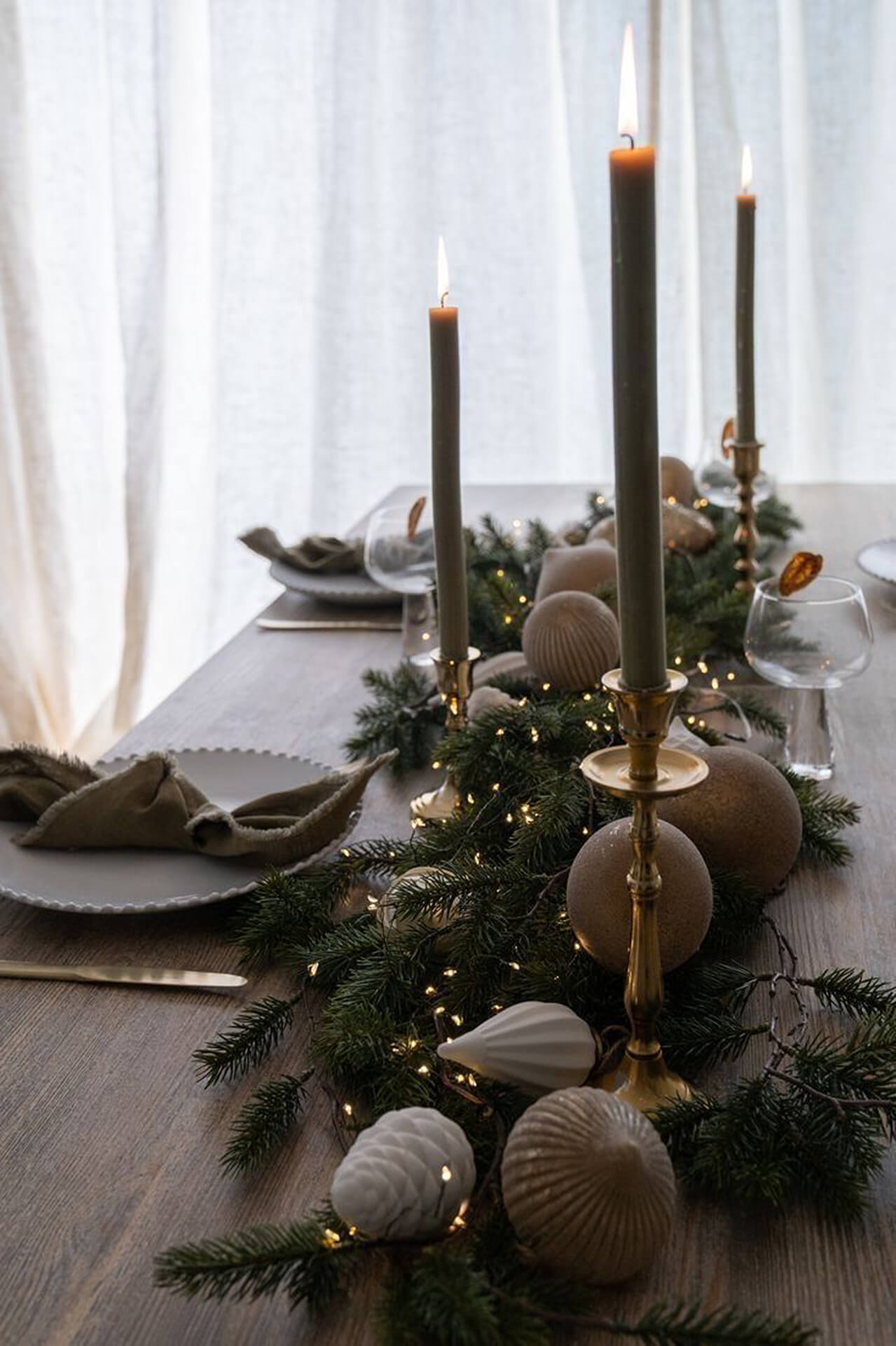 Festive Christmas Table with Candles and Holiday Decor Elegant Christmas table setting with tall candles, greenery, and festive decorations